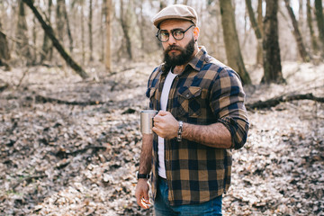 Fototapeta premium Bearded man drinking coffee in the wood