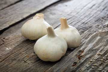 Three garlic bulbs, on wooden surface