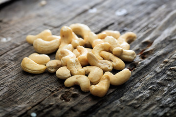 Heap of raw cashews, on wooden surface