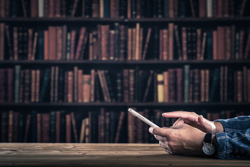 図書室でスマホを操作する男性