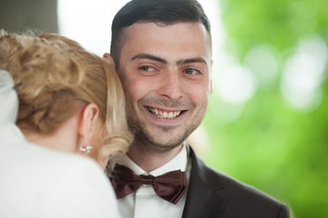 happy smiling just married groom with brown bow close up