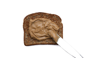 spreading peanut butter on wheat bread