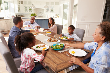 Multi generation black family serving a meal in the kitchen