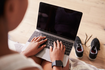 Fototapeta premium Young black woman using laptop computer, over-shoulder view