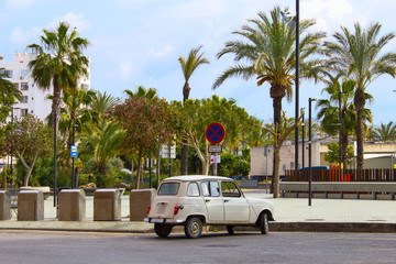 Old retro car in the tropical island scenery with palm trees