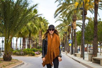 Beautiful woman walking down the street with palm trees