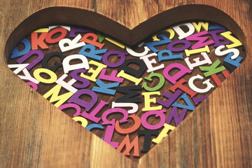 Many Colored Letters In The Wooden Heart Shape