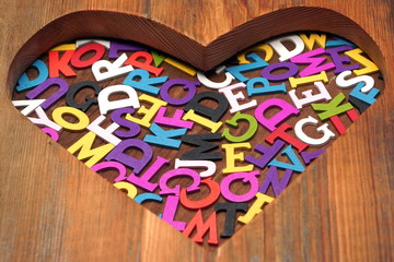 Many Colored Letters In The Wooden Heart Shape