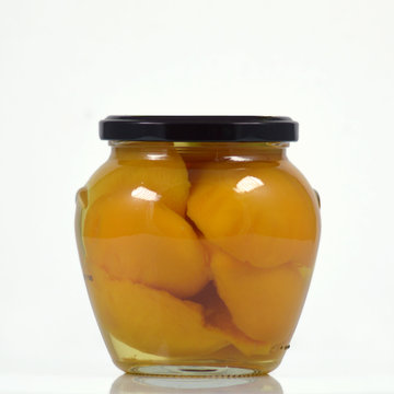 glass jar with peaches in syrup