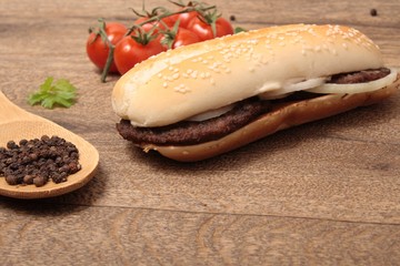 baguette with meat cutlets with onion and a spoon with pepper