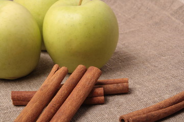 Ripe green apple with cinnamon sticks