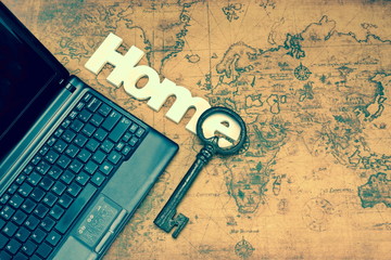 Home Sign, Key And Laptop On Old Map Background