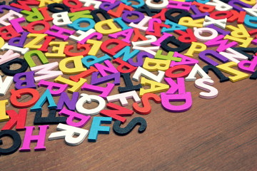 Random English Wooden Multicolored Letters On The Brown Wood Bac