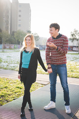 Young beautiful couple of lovers walking hand in hand outdoor in