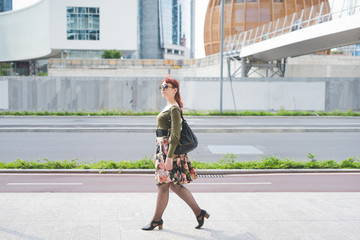 Full length side of young beautiful pin up redhead girl strollin