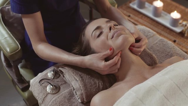 Young woman at exotic spa, getting kobido face massage