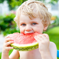 little toddler boy  eating healthy watermelon in summer