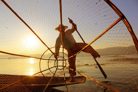 Fisherman silhouette with net at Inle lake