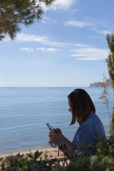 Naklejka premium Side view of black-haired woman with phone