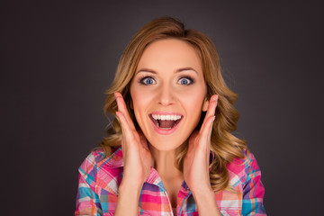 Portrait of surprised happy woman touching her face with open mo