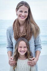 Happy mother standing with daughter at sea shore