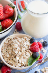 Rolled oats in a bowl with berries and milk