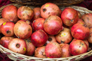 Group of fresh ripe pomegranate fruits in basket on display at local market