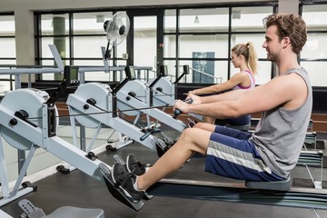 Man and woman working out on rowing machine