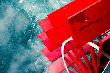 Steam ship on a cruise. Bright red wooden paddle wheels splash into the vivid blue clear waters. Motion blur. High contrast. Travel, abstract, nautical, coastal, fashion,  © Nicolae Merceanu