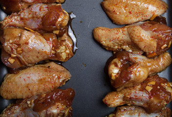 Marinated chicken wings on a black pan