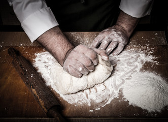 The process of making home bread by male hands. Toned - obrazy, fototapety, plakaty