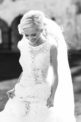 gently blonde bride in lace dress backgroung wall in garden