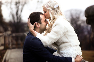 blonde bride and brunette groom walking near  old castle