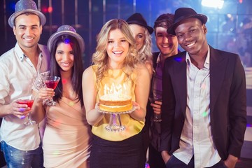 Happy friends celebrating birthday with cake