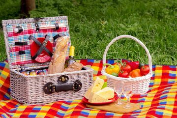Picnic on the grass. Picnic basket with vegetables and bread. A