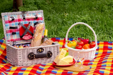 Fotobehang Picknick Picnic on the grass. Picnic basket with vegetables and bread. A