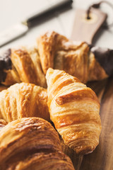 Delicious croissants on wooden board