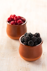 Blackberries and raspberries in ceramic pots