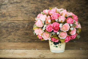 Plastic flowers with wooden background in vintage picture style, home interior equipment, Flowers set on wooden background. Hand made.