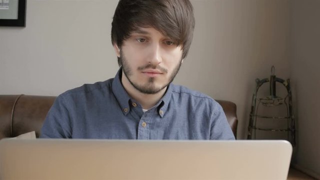 Happy Young Man Freelancer with Modern Laptop in Cafe taking Cup of Coffee