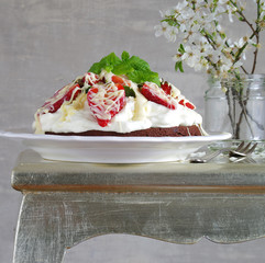 Schokoladenkuchen mit Sahnecreme und Erdbeeren