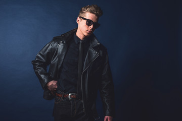 Macho retro 50s fashion man wearing sunglasses and leather jacke