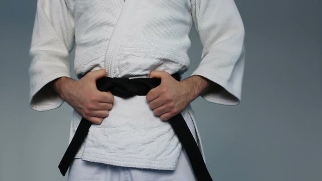 Martial arts Master tightening black belt. Slow motion