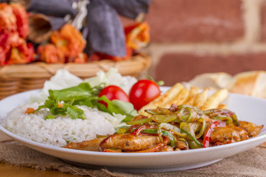 original fajita sizzling smoking Chicken breast with vegetables and sauce decorated with basil leaves
