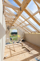 Attic room under construction with gypsum plaster boards. Roofing Construction Indoor. Wooden Roof...