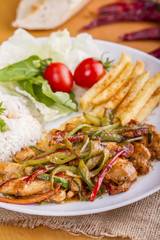 original fajita sizzling smoking Chicken breast with vegetables and sauce decorated with basil leaves