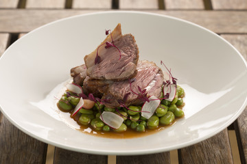 Roast rump of lamb with broad beans, peas & summer radishes 

