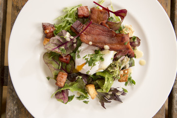 Salad Lyonnaise with pancetta, crisp leaves, softly poached egg, croutons & creamy dressing 
