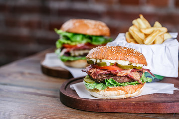 Fresh burger in bun with sesame with lettuce, tomato, beef and bacon.