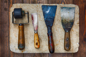 Retro design tools for artist workshop: rubber roller, different size putty knives on stone plate...